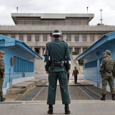 South Korean soldiers look towards the North Korean side as a North Korean solder approaches the U.N. truce village building that sits on the border of the Demilitarized Zone (DMZ), the military border separating the two Koreas, during the visit of U.S. Secretary of Defense Chuck Hagel, in Panmunjom, South Korea September 30, 2013. Hagel toured the Korean DMZ on Monday, at times under the watchful eye of North Korean soldiers, and said the Pentagon had no plan to reduce its 28,500-member force in the South despite budget constraints.     REUTERS/Jacquelyn Martin/Pool   (SOUTH KOREA - Tags: POLITICS MILITARY) - RTR3FFOW