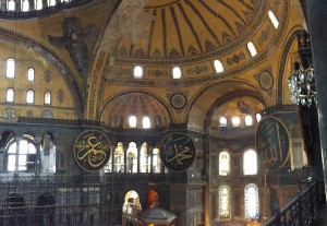 The inside of Hagia Sophia.  In the photo you can see gigantic circular-framed disks or medallions were hung on columns. These were inscribed with the names of Allah, Muhammad, among others.