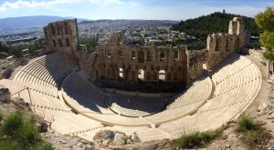 The Odeon of Herodes Atticus theater.  It was built in 161 AD by the Athenian magnate Herodes Atticus in memory of his wife, Aspasia Annia Regilla. It was originally a steep-sloped theater with a three-story stone front wall and a wooden roof made of expensive, cedar of Lebanon timber. It was used as a venue for music concerts with a capacity of 5,000.